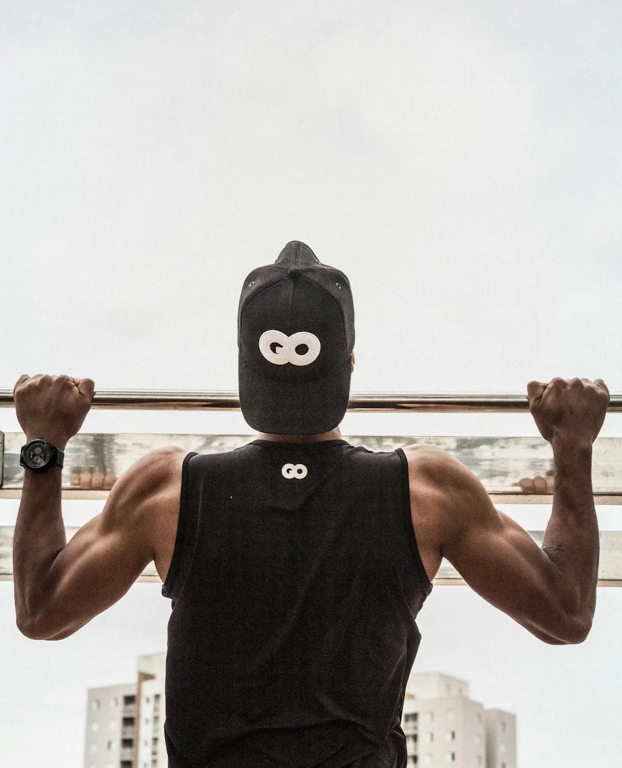 man lifting a bar wearing a GO hat